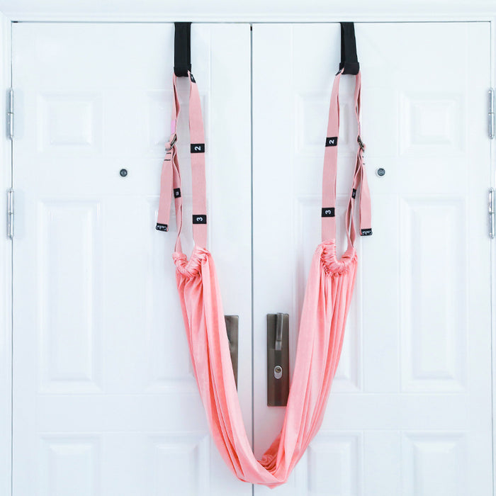 Pink yoga swing hanging on a white door