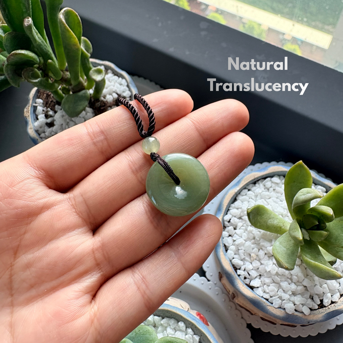 Hand polished Hetian jade pi disc pendant detail natural translucency under light