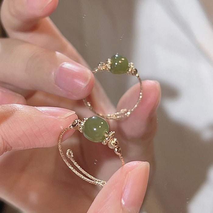 Hetian jade bead close-up on slim gold-toned band