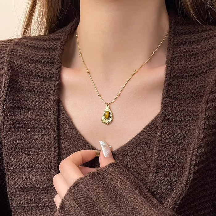 Woman wearing Tiger’s Eye pendant – modern minimalist jewelry style