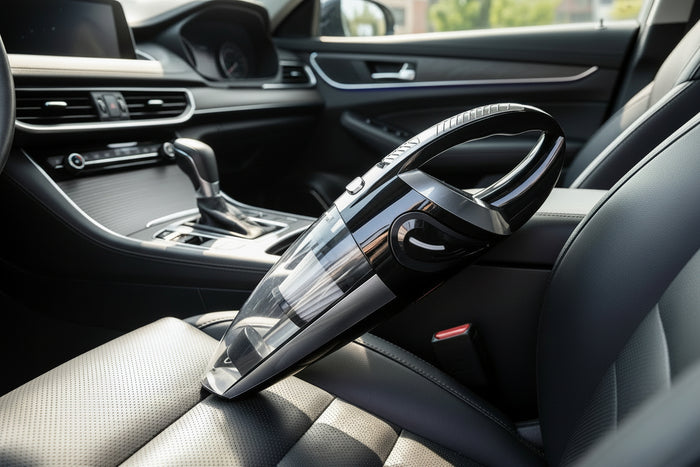 A handheld rechargeable vacuum cleaner in black color with a transparent dust container.
