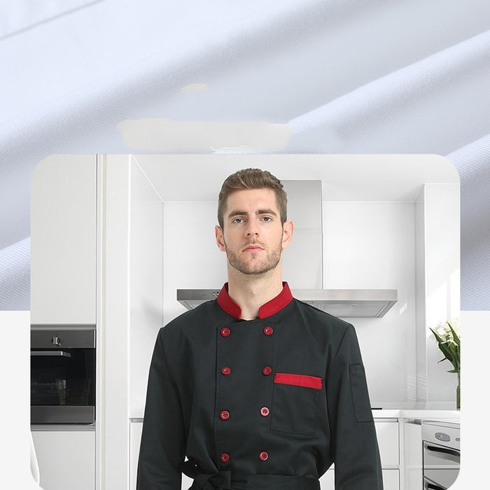 A man standing in a kitchen wearing a black chef coat with red buttons and trim.